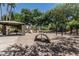 A playground with swings, slides, and climbing structures, shaded by mature trees and offering play space at 30 W Sheffield Ave, Gilbert, AZ 85233