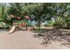 A colorful playground with slides, climbing features, and a merry-go-round, shaded by mature trees at 30 W Sheffield Ave, Gilbert, AZ 85233