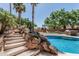 Inviting pool area features a rock waterfall and a playset in the backyard at 30 W Sheffield Ave, Gilbert, AZ 85233