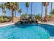 Inviting pool featuring a rock waterfall feature amidst palm trees and a serene backyard setting at 30 W Sheffield Ave, Gilbert, AZ 85233