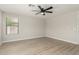 Minimalist bedroom with light wood floors, a ceiling fan, and natural light from the window at 3035 W Roberta Dr, Phoenix, AZ 85083