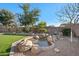 Serene backyard featuring a rock water feature and lush landscaping, perfect for outdoor relaxation and enjoyment at 3085 E Parkview Dr, Gilbert, AZ 85295