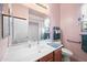 Cozy bathroom with pink walls, a large mirror, cherry-wood cabinets, and essential fixtures at 3085 E Parkview Dr, Gilbert, AZ 85295