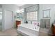 Bright bathroom with a jacuzzi tub, ample counter space, and natural light from a glass block window at 3085 E Parkview Dr, Gilbert, AZ 85295