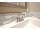 Close-up of bathroom sink features a modern faucet and stylish backsplash tiling at 319 S 90 Pl, Mesa, AZ 85208