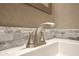 Close-up of bathroom sink features a modern faucet and stylish backsplash tiling at 319 S 90 Pl, Mesa, AZ 85208