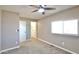 Bright, carpeted bedroom with a ceiling fan, window, and walk-in closet at 319 S 90 Pl, Mesa, AZ 85208