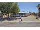 Charming single-story home features a covered parking, lush trees, and gravel landscaping at 319 S 90 Pl, Mesa, AZ 85208