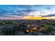 Stunning aerial view of the stone and stucco home with a tile roof set against a vibrant sunset backdrop at 3553 N Crystal Peak Cir, Mesa, AZ 85207