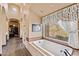 Well-lit bathroom with soaking tub and large window overlooking nature at 3553 N Crystal Peak Cir, Mesa, AZ 85207