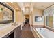 Bathroom with dual vanities, soaking tub, and walk-in closet access at 3553 N Crystal Peak Cir, Mesa, AZ 85207
