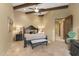 Bedroom with beamed ceilings, sitting bench, neutral colors, and decorative bedside lamps at 3553 N Crystal Peak Cir, Mesa, AZ 85207