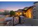 Stone facade home entrance with decorative iron gate and exterior lighting at twilight at 3553 N Crystal Peak Cir, Mesa, AZ 85207