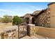Stone entryway with a gated courtyard that leads to a beautiful wood front door, surrounded by desert plants at 3553 N Crystal Peak Cir, Mesa, AZ 85207