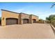 Impressive three-car garage with custom doors and stone accents, set on a beautifully paved driveway at 3553 N Crystal Peak Cir, Mesa, AZ 85207