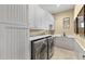 Laundry room with stainless steel front-load washer and dryer and custom grey cabinets at 3553 N Crystal Peak Cir, Mesa, AZ 85207