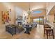 Spacious living room with stone fireplace, large windows, and chandelier, offering a bright and inviting atmosphere at 3553 N Crystal Peak Cir, Mesa, AZ 85207