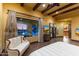 Luxurious main bedroom with exposed beams, expansive windows, and outdoor views to the pool and patio at 3553 N Crystal Peak Cir, Mesa, AZ 85207
