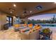 Covered outdoor living space with plush seating, a pool view, and ample lighting for evening enjoyment at 3553 N Crystal Peak Cir, Mesa, AZ 85207