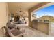 Covered patio with wicker chairs, outdoor kitchen, and views of the pool and desert landscape at 3553 N Crystal Peak Cir, Mesa, AZ 85207