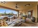 Inviting covered patio with stylish outdoor furniture, a ceiling fan, and views of the pool and desert landscape at 3553 N Crystal Peak Cir, Mesa, AZ 85207