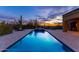 Stunning backyard pool at sunset with desert landscaping, creating a serene and luxurious outdoor space at 3553 N Crystal Peak Cir, Mesa, AZ 85207