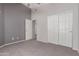 A simple bedroom with neutral carpet and paint, and double doors to a closet at 3834 W Commonwealth Ave, Chandler, AZ 85226