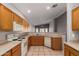 A cozy kitchen featuring wooden cabinets, laminate countertops, white appliances, and tile flooring at 3834 W Commonwealth Ave, Chandler, AZ 85226