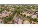 Aerial view of a residential community with homes featuring tile roofs, desert landscaping, walking paths, and mature trees at 4152 S Bandit Ct, Gilbert, AZ 85297