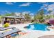 The backyard features a desert landscaped pool, rock waterfall feature, and covered outdoor kitchen and bar at 4152 S Bandit Ct, Gilbert, AZ 85297