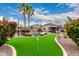 Beautiful backyard featuring a putting green, pool, gazebo, desert landscaping and mature palm trees at 4152 S Bandit Ct, Gilbert, AZ 85297