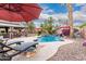 Beautiful backyard oasis with pool, outdoor kitchen, gazebo, and lounge chairs under palm trees at 4152 S Bandit Ct, Gilbert, AZ 85297