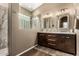 Bathroom featuring double sinks with a wood vanity and a glass block window over a marble shower at 4152 S Bandit Ct, Gilbert, AZ 85297