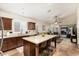 Kitchen island with seating, dark wood cabinets, and a view of the living room and backyard at 4152 S Bandit Ct, Gilbert, AZ 85297