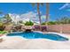 A desert landscaped pool with rock waterfall feature and palm trees graces the backyard at 4152 S Bandit Ct, Gilbert, AZ 85297