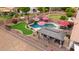 Aerial view of outdoor living space including a putting green, pool, waterfall, and covered outdoor kitchen at 4152 S Bandit Ct, Gilbert, AZ 85297