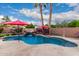Backyard pool with a waterfall feature, surrounded by lush greenery and lounging areas at 4152 S Bandit Ct, Gilbert, AZ 85297