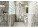 Shower featuring marble tiling, a glass block window, and shower niche for toiletries at 4152 S Bandit Ct, Gilbert, AZ 85297