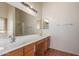 Bathroom featuring double vanity, large mirror, and wood-look floors at 42796 W Wild Horse Trl, Maricopa, AZ 85138