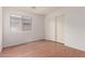Bedroom with wood-look floors, natural light, and a sliding door closet at 42796 W Wild Horse Trl, Maricopa, AZ 85138