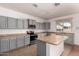 Spacious kitchen with gray cabinets, modern appliances, and a large island, great for cooking at 42796 W Wild Horse Trl, Maricopa, AZ 85138