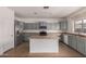 Kitchen with stainless steel appliances, gray cabinets, and an island for food preparation at 42796 W Wild Horse Trl, Maricopa, AZ 85138