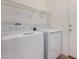 Bright laundry area includes storage shelf and white front loading washer and dryer at 42796 W Wild Horse Trl, Maricopa, AZ 85138