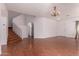 Large living room with hardwood floors, staircase, entry door and chandelier lighting at 42796 W Wild Horse Trl, Maricopa, AZ 85138