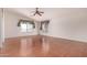 Spacious living room features vaulted ceiling, ceiling fan, and wood-look floors at 42796 W Wild Horse Trl, Maricopa, AZ 85138