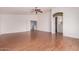 Bright living room with ceiling fan, wood-look flooring and access to bathroom at 42796 W Wild Horse Trl, Maricopa, AZ 85138