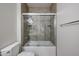 Neutral tiled bathroom with glass shower/tub, toilet, and towel bar at 45633 W Mountain View Rd, Maricopa, AZ 85139