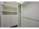 White walk-in closet with adjustable shelving and storage drawers for optimal organization at 45633 W Mountain View Rd, Maricopa, AZ 85139