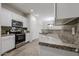 Updated kitchen with stainless steel oven, stone countertops, and bright white cabinets at 45633 W Mountain View Rd, Maricopa, AZ 85139