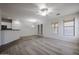 Open-concept living space with wood-look floors, neutral paint, chandelier, and access to the kitchen at 45633 W Mountain View Rd, Maricopa, AZ 85139
